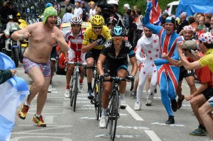 Spectators with the British flag run alongside Richie Porte of Australia, Christopher Froome of Britain, wearing the overall leader's yellow jersey, and Joaquim Rodriguez of Spain as they climb towards Alpe-d'Huez pass during the eighteenth stage of the Tour de France cycling race over 172.5 kilometers (107.8 miles) with start in Gap and finish in Alpe-d'Huez, France, Thursday July 18, 2013. (AP Photo/Bernard Papon, Pool)